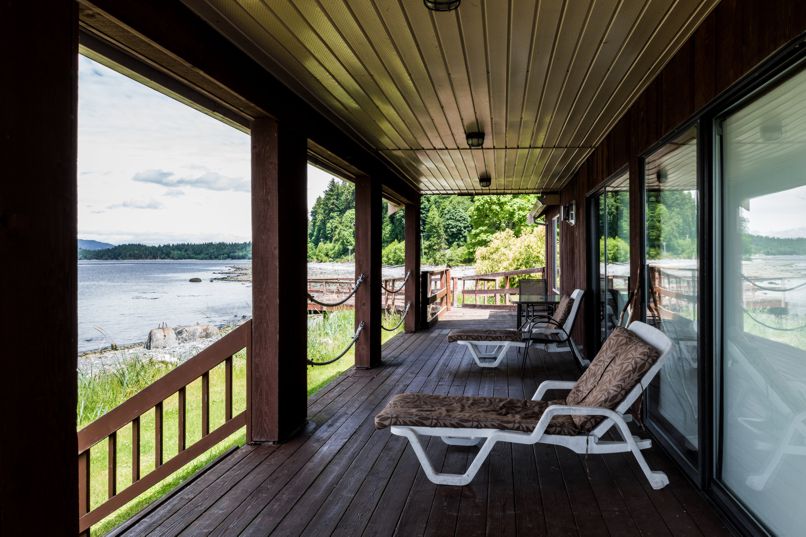 Wharfhouse Cottage at Cape Mudge RV Park, lounge chairs on the wrap around deck looking on to the ocean