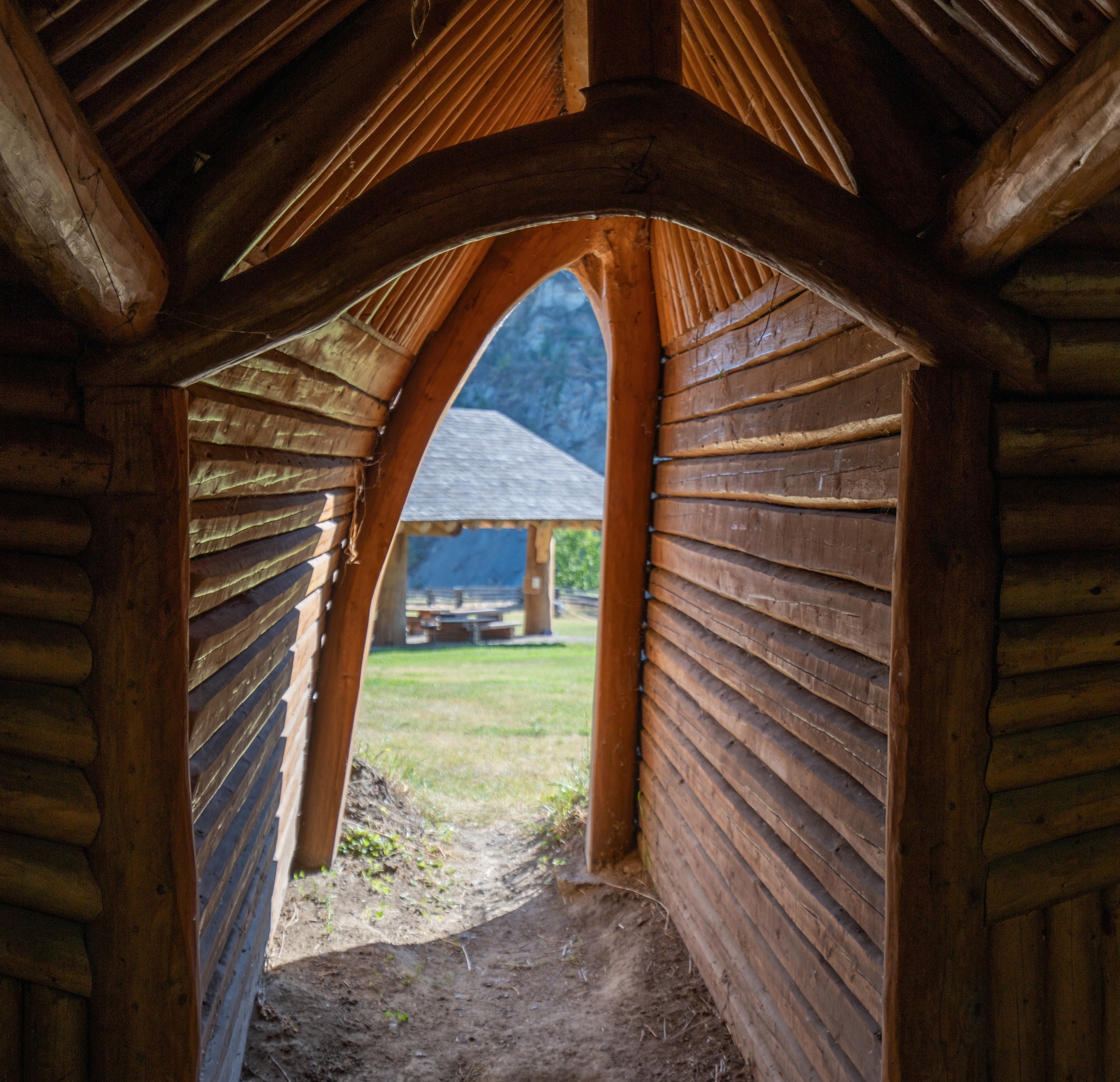Interior view looking out the entrance of a pit house at Xatsull Heritage Village