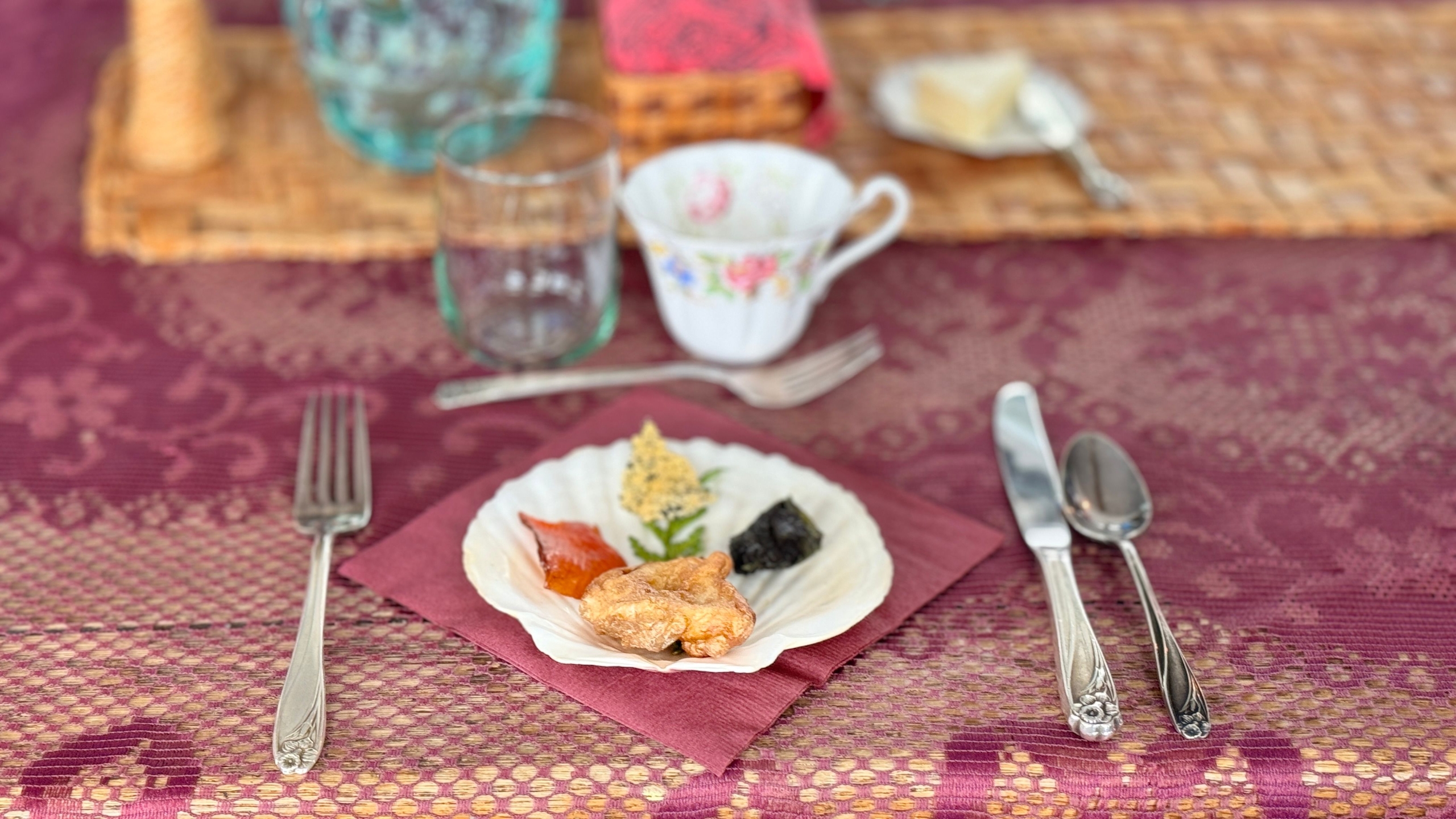 Bannock, salmon, oolichan grease, and cedar garnish on a clamshell plate on a Haida tablecloth at Keenawaii's Kitchen