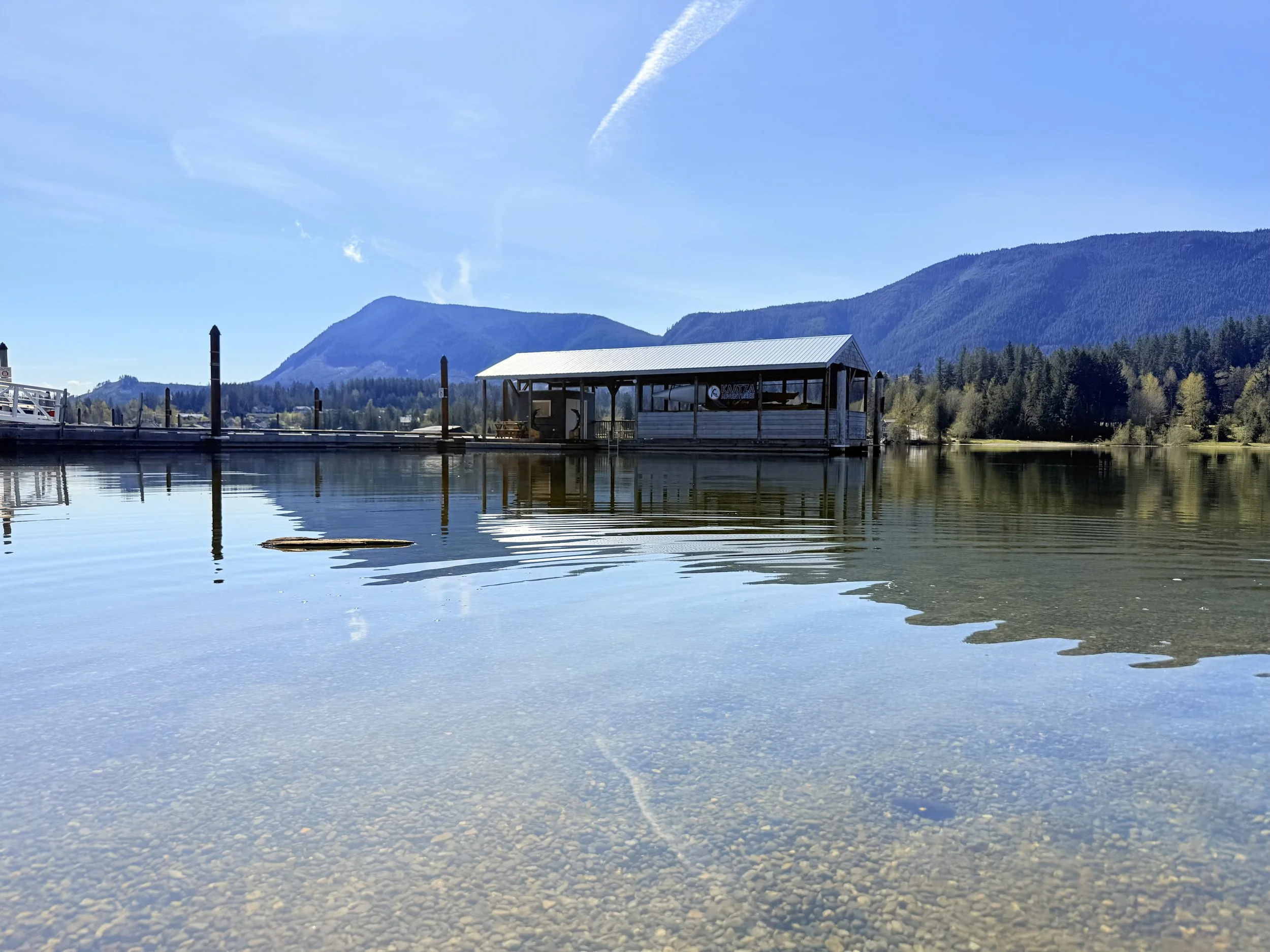 Kaatza Adventures, lake Cowichan with floating shed on a sunny day with mountains and trees in the background