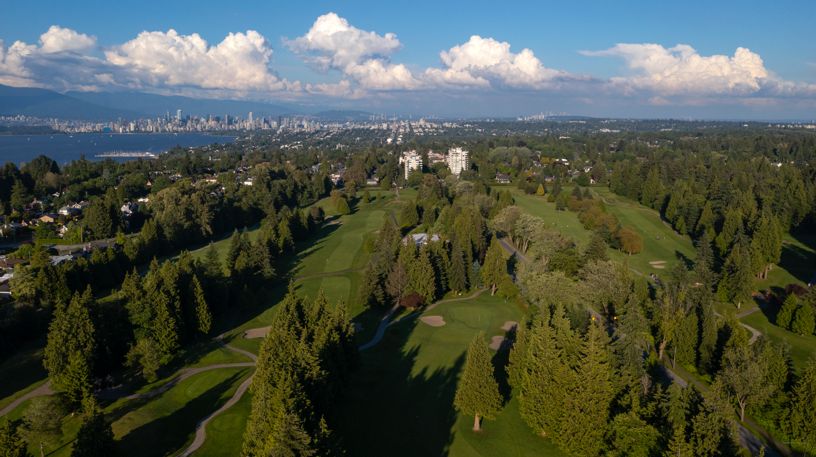 University Golf Club, Vancouver, BC- 18 hole golf course. greeen grass, large green pine, cedar and fir trees, blue sky with scattered clouds