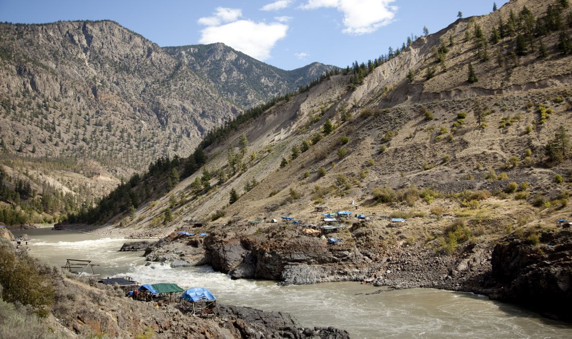 Tents pitched by a river in the mountains
