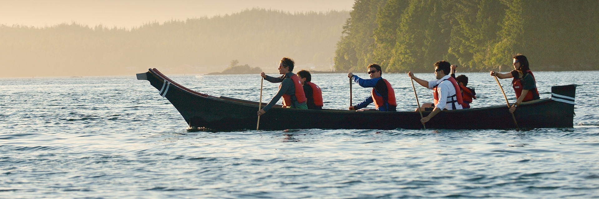 People paddling together in a canoe on a body of water